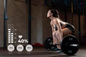 A woman performs a deadlift in a gym, focusing on her form while lifting a barbell loaded with weights. Fitness data is displayed.