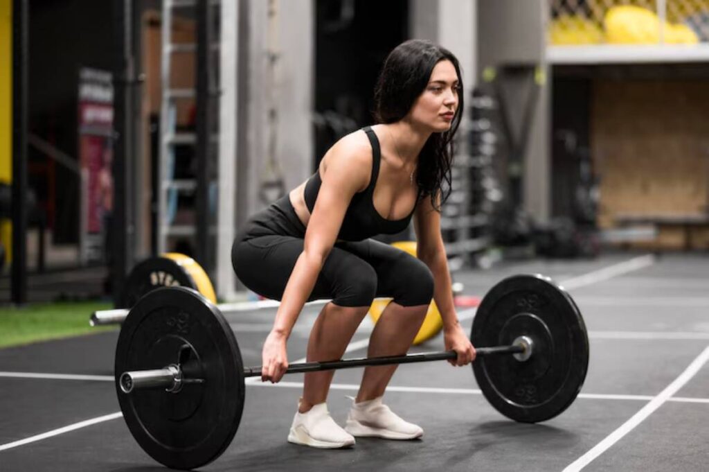 A person in athletic wear performs a squat with a barbell in a gym, showcasing strength and focus.