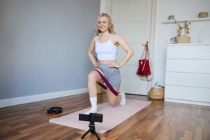 A person in athletic wear performs a lunge with a resistance band in a stylish, minimalist home gym setting.