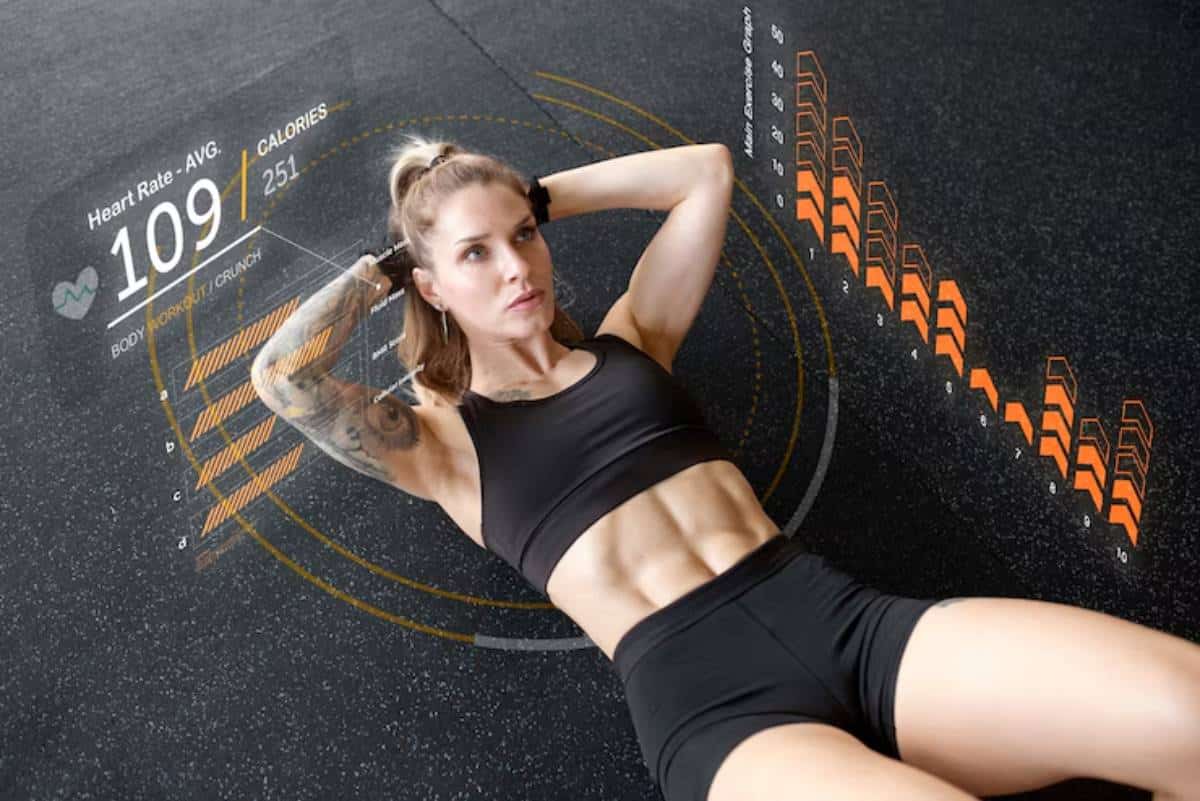 A fit woman performs a crunch on a gym floor, displaying her toned abs, with digital fitness metrics overlay including heart rate and calories burned.